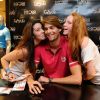 Camille Lacourt pose en compagnie de deux de ses fans aux Galeries Lafayette, à Paris, samedi 1er septembre 2012.