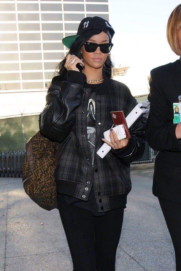 Rihanna à LAX, l'aéroport de Los Angeles, porte une casquette Trapstar, une veste APC pour Carhartt, un t-shirt Givenchy et un sac à dos Fendi. Los Angeles, le 12 avril 2012.
