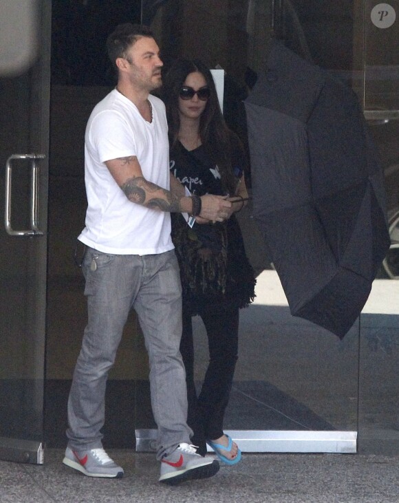 Megan Fox et Brian Austin Green dissimulés derrière un parapluie, à Los Angeles, le 23 septembre 2012.