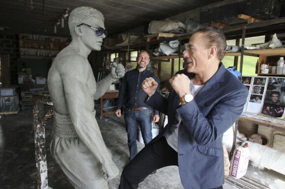 Jean-Claude Van Damme avec l'artiste Guy Ducheyne qui vient de signer une statue à l'effigie de l'acteur à Anderlecht, le 17 septembre 2012.