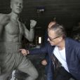 Jean-Claude Van Damme avec l'artiste Guy Ducheyne qui vient de signer une statue à l'effigie de l'acteur belge à Anderlecht, le 17 septembre 2012.