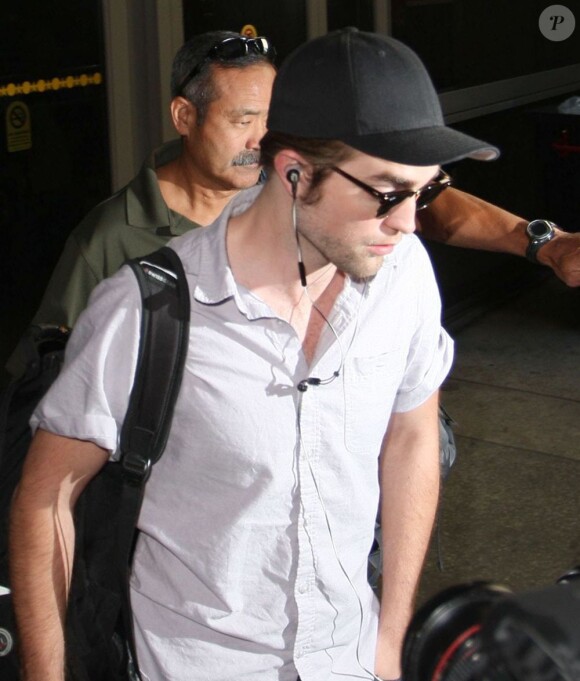 Kristen Stewart et Robert Pattinson sortent séparément de l'aéroport de Los Angeles le 25 octobre 2012. K-Stew venait du Japon et R-Patz d'Australie et tous deux portent une casquette