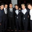 Les One Direction reçus par la reine Elizabeth II, accompagnés par Robbie Williams, à Londres le 19 novembre 2012.