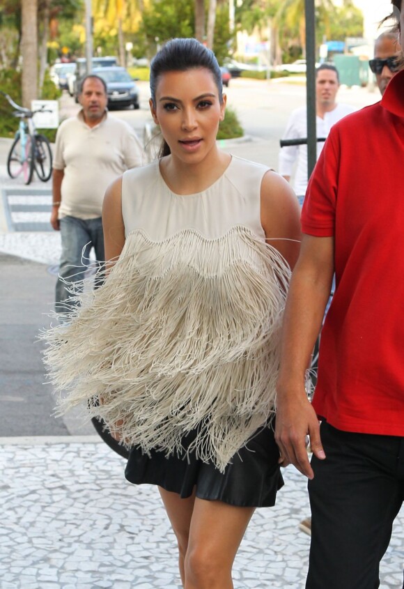 Kim Kardashian, stylée dans un top à franges et une mini-jupe en cuir, profite d'une belle journée à Miami Beach. Le 4 décembre 2012.