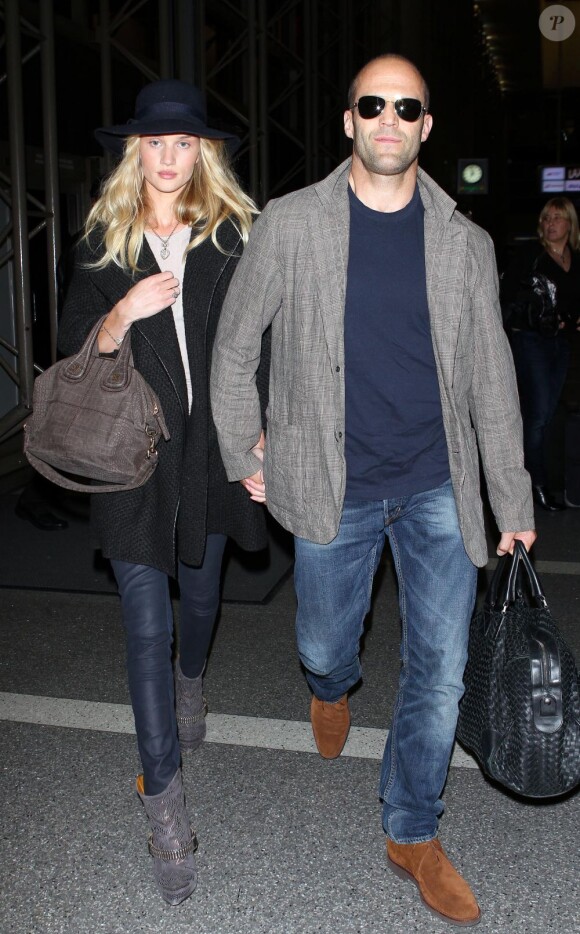 Rosie Huntington-Whiteley, stylée à son arrivée à l'aéroport de Los Angeles avec Jason Statham, porte ses pièces fétiches : un sac Nightingale de Givenchy et des bottines Isabel Marant. Le 10 décembre 2012.