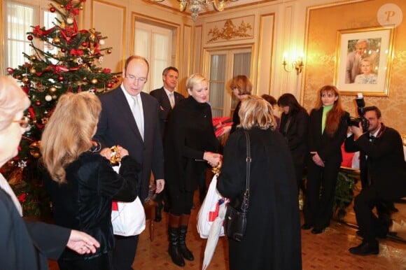 Le prince Albert de Monaco, président d'honneur de l'association, et la princesse Charlene distribuaient le 14 décembre 2012 avec la Croix-Rouge monégasque des colis alimentaires pour les plus démunis du Rocher.