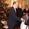 Le prince Albert, président d'honneur de l'association, et la princesse Charlene de Monaco distribuaient le 14 décembre 2012 avec la Croix-Rouge monégasque des colis alimentaires pour les plus démunis du Rocher.