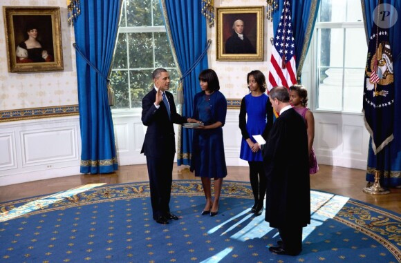 Barack Obama prête serment devant le juge de la Cour suprême John Roberts, accompagné par sa femme Michelle Obama, dans le Salon Bleu de la Maison-Blanche, à Washington, le 20 janvier 2013.