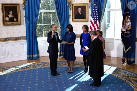 Barack Obama prête serment devant le juge de la Cour suprême John Roberts, accompagné par sa femme Michelle Obama, dans le Salon Bleu de la Maison-Blanche, à Washington, le 20 janvier 2013.