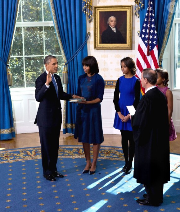 Barack Obama prête serment devant le juge de la Cour suprême John Roberts, accompagné par sa femme Michelle Obama, dans le Salon Bleu de la Maison-Blanche, à Washington, le 20 janvier 2013.