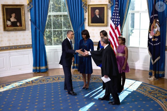 Barack Obama prête serment devant le juge de la Cour suprême John Roberts, accompagné par sa femme Michelle Obama, dans le Salon Bleu de la Maison-Blanche, à Washington, le 20 janvier 2013.