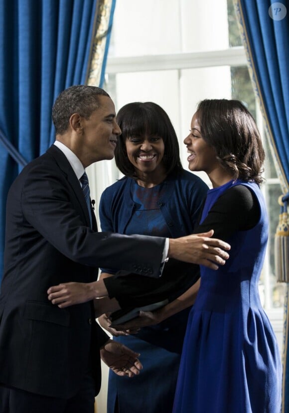 Barack Obama prête serment devant le juge de la Cour suprême John Roberts, accompagné par sa femme Michelle Obama, et sa fille aînée Malia, dans le Salon Bleu de la Maison-Blanche, à Washington, le 20 janvier 2013.