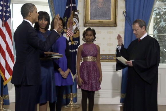 Barack Obama prête serment devant le juge de la Cour suprême John Roberts, accompagné par sa femme Michelle Obama et ses filles Malia et Sasha, dans le Salon Bleu de la Maison-Blanche, à Washington, le 20 janvier 2013.