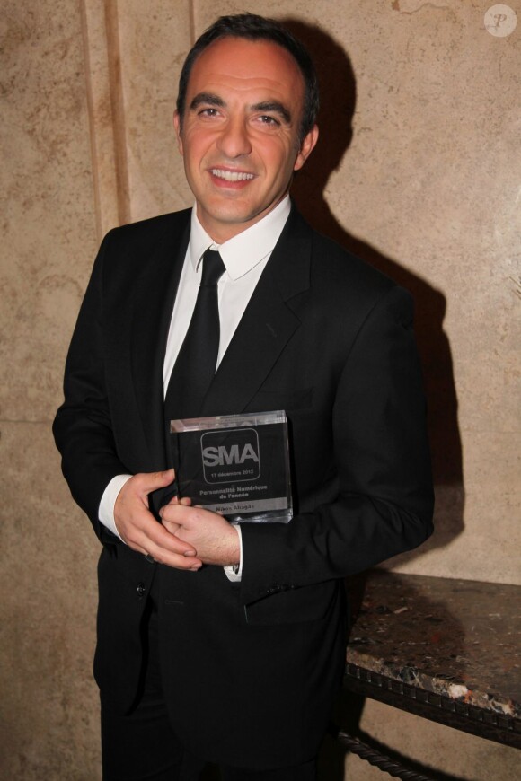 Nikos Aliagas, heureux, reçoit le prix de la meilleure personnalité numérique de l'année lors des SMA 2012 dans les locaux de SwissLife Banque Privée à Paris, le 17 décembre 2012.