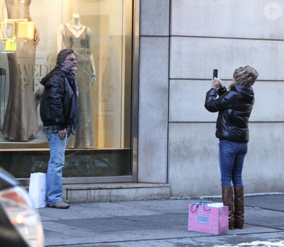 Goldie Hawn prend en photo Kurt Russell devant la vitrine d'une boutique qui présente un portrait géant de leur fille Kate Hudson, à New York, le 26 janvier 2013.