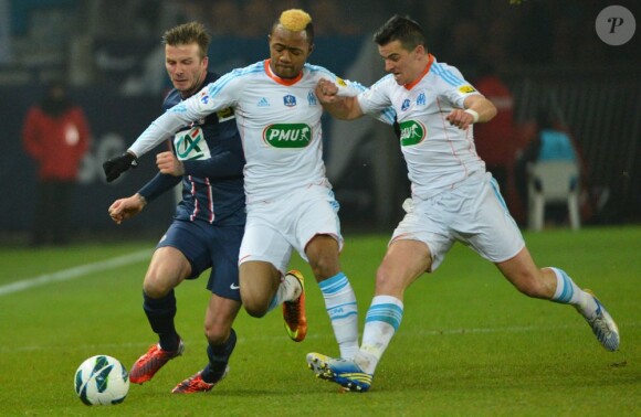 David Beckham pris par Jordan Ayew et Joey Barton lors du match entre le Paris Saint-Germain et l'Olympique de Marseille (2-0) le 27 février 2013 au Parc des Princes à Paris