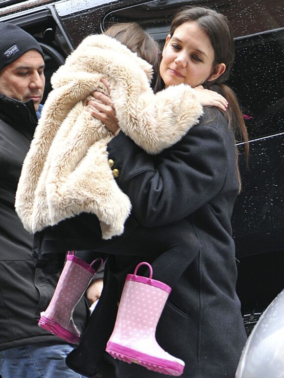 Malgré ses jolies bottes roses, Suri ne daigne mettre un pied sur le sol enneigé de New York. Le 8 mars 2013.