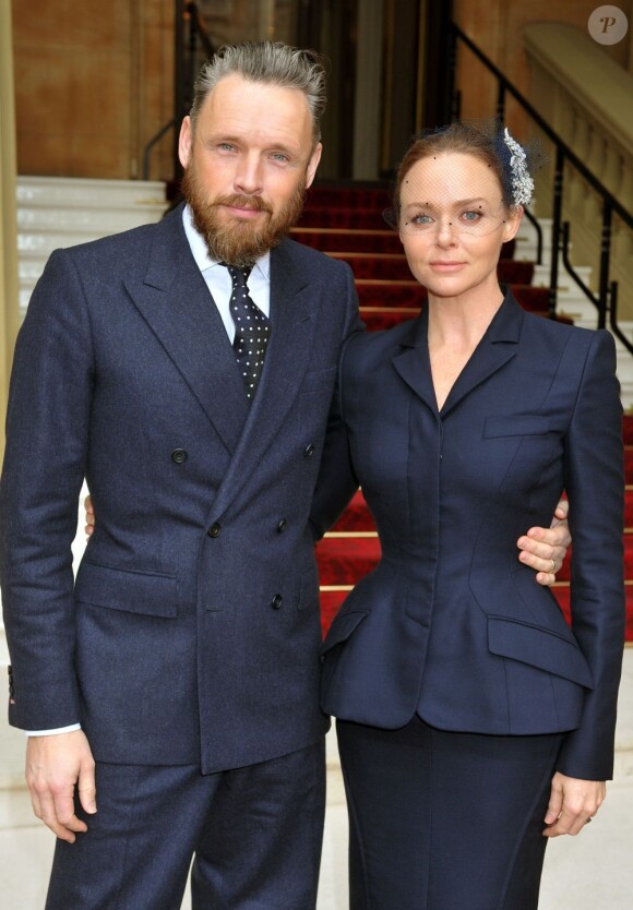 Stella McCartney et son mari Alasdhair Willis lors de la cérémonie de remise de l'Ordre d'Officier de l'Empire Britannique à Buckingham Palace. Londres, le 26 mars 2013.