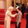 Victoria Pendleton reçoit son Ordre de Commandant de l'Empire Britannique des mains de la reine Elizabeth II à Buckingham Palace. Londres, le 26 mars 2013.