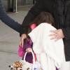 Katie Holmes cache Suri Cruise à son arrivée à l'aéroport JFK à New York le 29 mars 2013.