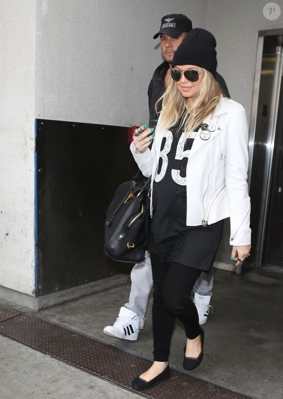 Fergie, enceinte, et son mari Josh Duhamel arrivent à l'aéroport de Los Angeles, le 8 avril 2013.