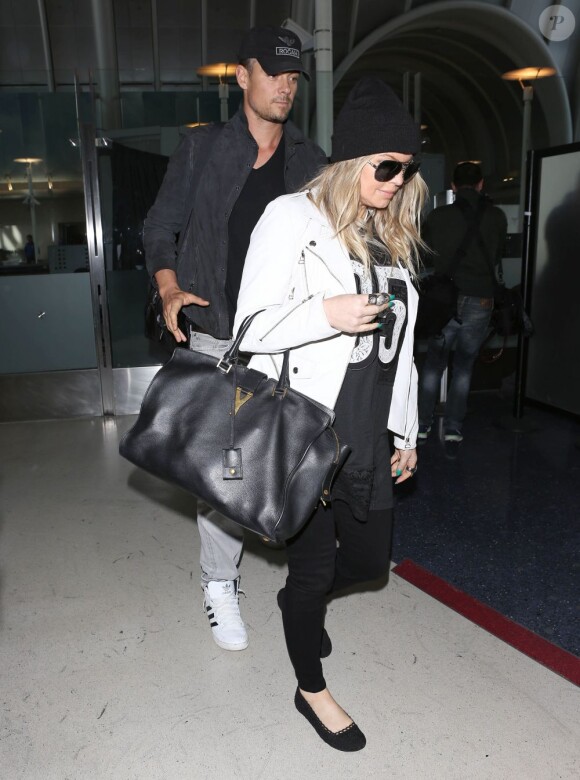 Fergie, enceinte, et son mari Josh Duhamel arrivent à l'aéroport de Los Angeles, le 8 avril 2013.