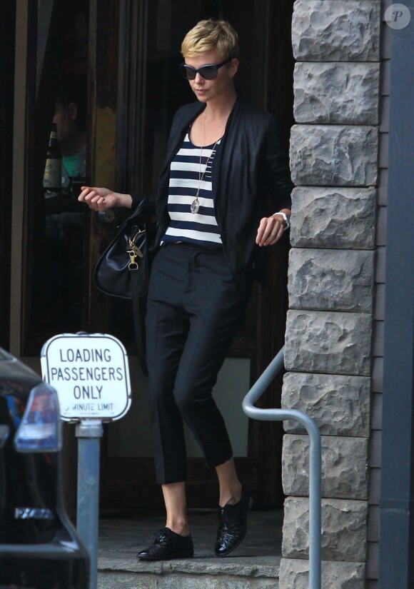 Charlize Theron, passablement énervée à la sortie d'un restaurant avec sa mère Gerda et son fils Jackson, à Los Angeles, le 5 mai 2013.