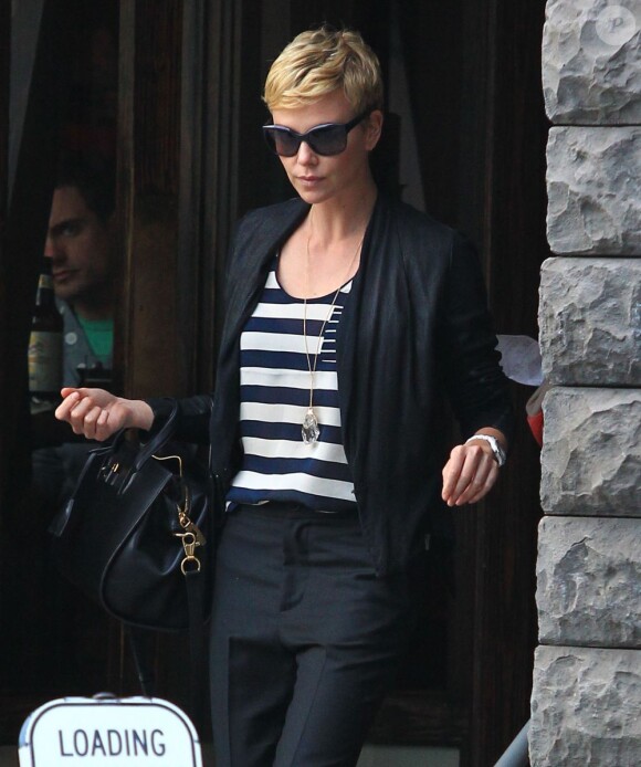 Charlize Theron, passablement énervée à la sortie d'un restaurant avec sa mère Gerda et son fils Jackson, à Los Angeles, le 5 mai 2013.