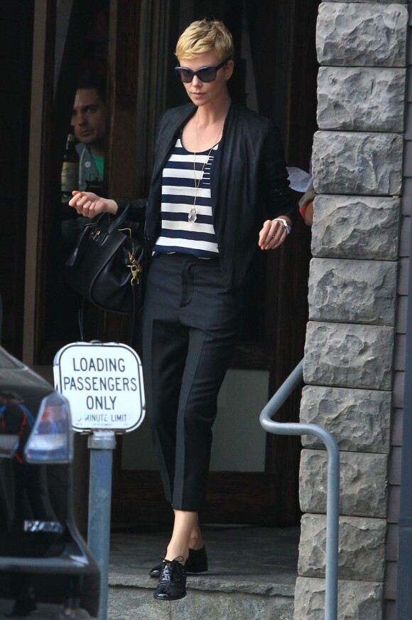 Charlize Theron, passablement énervée à la sortie d'un restaurant avec sa mère Gerda et son fils Jackson, à Los Angeles, le 5 mai 2013.