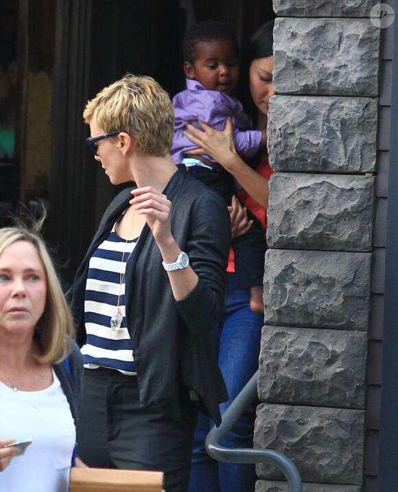 Charlize Theron, passablement énervée à la sortie d'un restaurant avec sa mère Gerda et son fils Jackson, à Los Angeles, le 5 mai 2013.