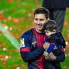 La star Lionel Messi et son fils Thiago au Camp Nou lors des célébrations du titre de champion d'Espagne du FC Barcelone le 19 mai 2013.