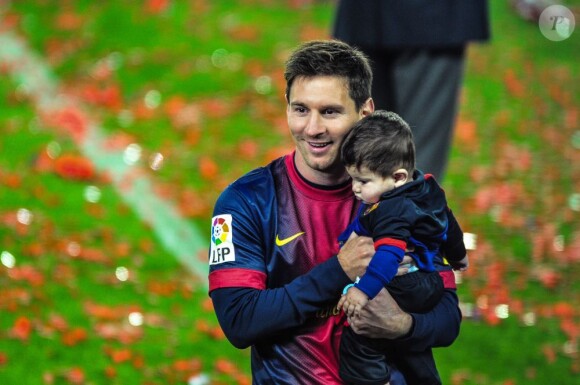 La star Lionel Messi et son fils Thiago au Camp Nou lors des célébrations du titre de champion d'Espagne du FC Barcelone le 19 mai 2013.
