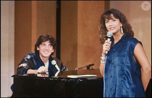 Sophie Marceau et Patrick Bruel chantent ensemble sur un plateau télé en 1985.