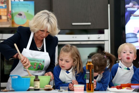 Camilla Parker Bowles, duchesse de Cornouailles, prépare du porridge avec l'aide de jeunes enfants de la Broughshane Nursery School qui se situe dans le comté d'Antrim, dans le nord de l'Irlande. Le 25 juin 2013.