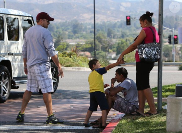 Exclusif - Le petit ami de Britney Spears, David Lucado, descend de la voiture pour donner de l'argent à un sans-abri à Fillmore, le 4 juillet 2013.