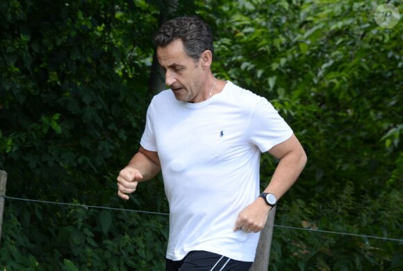 Nicolas Sarkozy, escorté par ses gardes du corps, fait un jogging au Bois de Boulogne. Paris, le 5 juillet 2013.