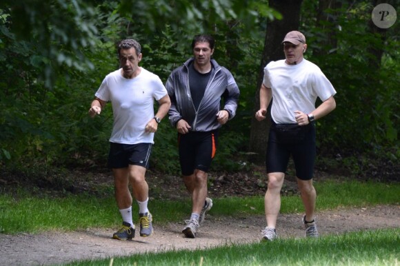 L'ancien président Nicolas Sarkozy et ses gardes du corps en plein footing au Bois de Boulogne. Paris, le 5 juillet 2013.