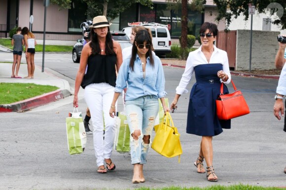 Kourtney Kardashian et Kris Jenner, filmées par les caméras de Keeping up with the Kardashians, quittent une boutique de jouets pour enfants. Calabasas, le 5 juillet 2013.