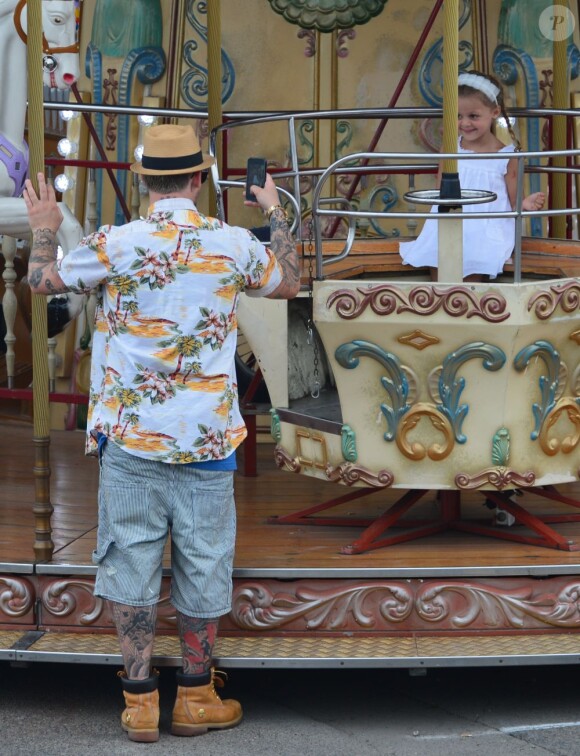 Joel Madden immortalise sa fille Harlow sur un manège. Saint-Tropez, le 22 juillet 2013.