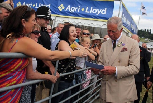Une enveloppe bleue contenant 10 livres, destinée au petit prince de Cambridge... Le prince Charles et Camilla Parker Bowles, duchesse de Cornouailles, en visite au Royal Welsh Show le 24 juillet 2013 à Builth Wells, au Pays de Galles.