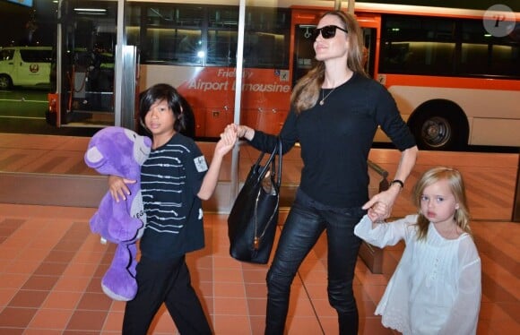 Brad Pitt et Angelina Jolie arrivant à l'aéroport de Tokyo-Haneda avec trois de leurs enfants (Pax, Knox et Vivienne), le 28 Juillet 2013. Angie tient dans ses mains Pax et Vivienne