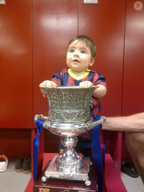 Milan pose avec la Supercoupe d'Espagne remportée par son père Gerard Piqué et le FC Barcelone le 29 août 2013 au Camp Nou.