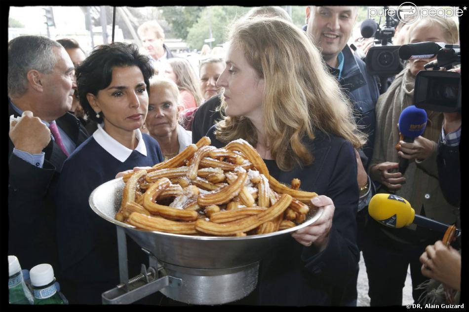 Rachida Dati et Nathalie Kosciusko-Morizet devant un énorme saladier de churros lors d&#039;une sortie dans le VIIe arrondissement de Paris au pied de la Tour Eiffel dans le cadre de la campagne électorale pour la mairie de Paris, le 19 septembre 2013