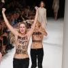 Deux activistes de l'association Femen défilent seins nus lors de la présentation Nina Ricci au Jardin des Tuileries. Paris, le 26 septembre 2013.