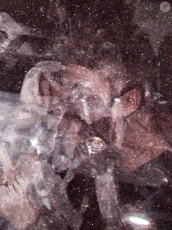 Le chanteur Justin Bieber sort du bordel Centauros, caché sous une couverture noire, à Rio de Janeiro, le 1er novembre 2013.