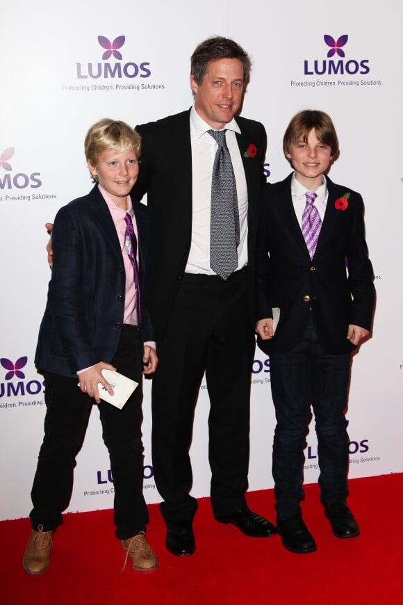Hugh Grant et son filleul Damian Hurley, fils de son ex Liz Hurley, accompagné d'un ami lors d'un gala de charité pour l'association Lumos, animé par J. K. Rowling, le 9 novembre 2013 à Londres