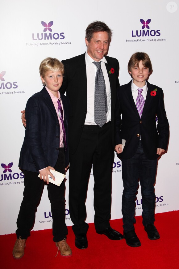 Hugh Grant et son filleul Damian Hurley (à droite), fils de son ex-Liz Hurley, accompagné d'un ami, lors d'un gala de charité pour l'association Lumos, animé par J. K. Rowling, le 9 novembre 2013 à Londres