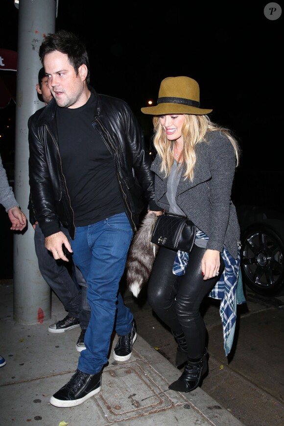 Hilary Duff, de sortie avec son mari Mike Comrie, porte un chapeau Rag & Bone, un sac Chanel (modèle Boy), une veste et un top gris, une chemise à carreaux nouée à la taille, un pantalon en cuir et des bottines Isabel Marant. Los Angeles, le 9 novembre 2013.