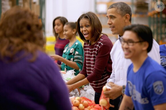 Barack Obama a distribué des colis de nourriture avec ses filles Malia et Sasha, ainsi que son épouse Michelle, dans les locaux de l'association Capital Area Food Bank à Washington, le 27 novembre 2013.
