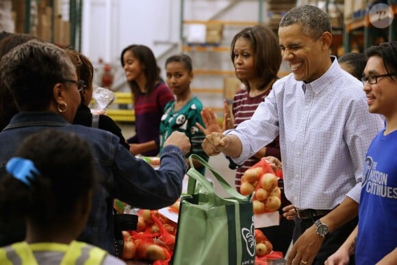 Barack Obama a distribué des colis de nourriture avec ses filles Malia et Sasha, ainsi que son épouse Michelle, dans les locaux de l'association Capital Area Food Bank à Washington, le 27 novembre 2013.